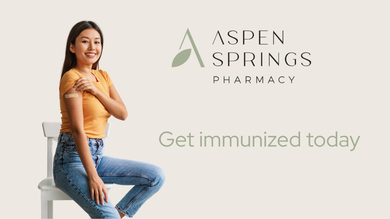 A smiling woman with teen who has a vaccine bandage on her shoulder sitting on her lap